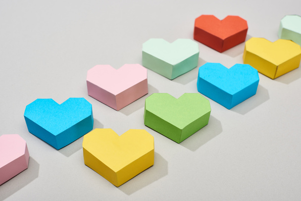 Colorful decorative papers in heart shape on grey background - Foto, Imagen