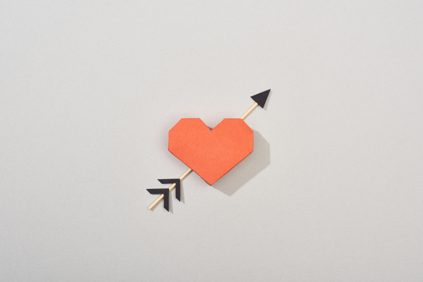 Top view of decorative paper heart with arrow on grey background - Foto, Imagem
