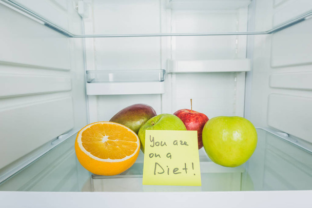Yanında diyet mektupları ve buzdolabında taze meyveler var. - Fotoğraf, Görsel