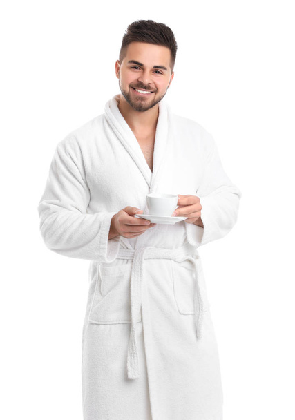 Handsome man in bathrobe with cup of coffee on white background - Photo, Image