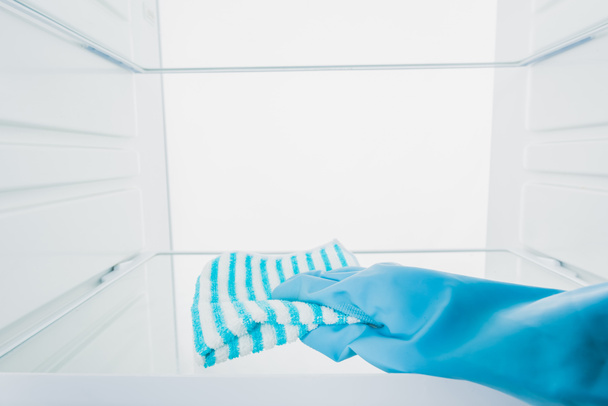 Cropped view of woman in rubber glove cleaning fridge shelf isolated on white - Φωτογραφία, εικόνα