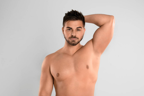 Young man showing hairless armpit after epilation procedure on l - Foto, immagini