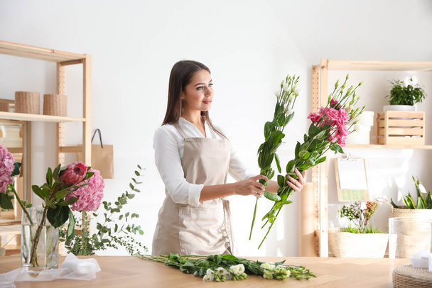 Florist making beautiful bouquet at table in workshop - Фото, изображение