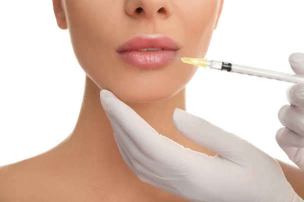 Woman getting lip injection on white background, closeup - Foto, immagini
