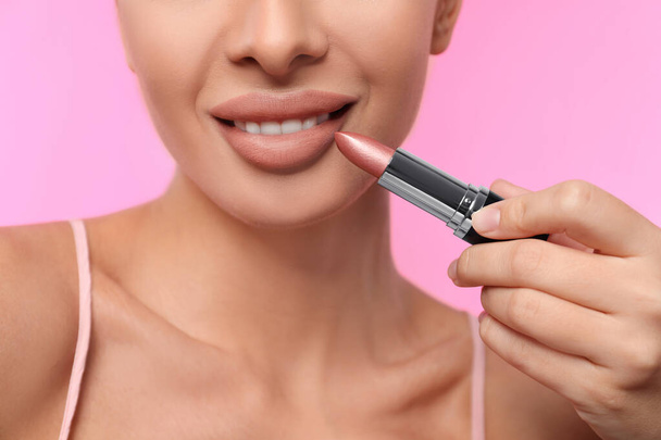 Woman with matte lipstick on pink background, closeup - 写真・画像