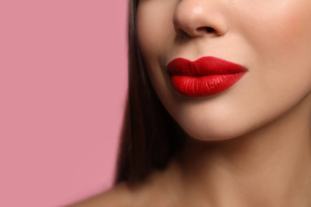 Woman with red lipstick on pink background, closeup - Foto, afbeelding