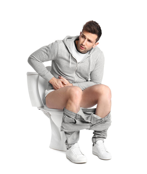 Man suffering from diarrhea on toilet bowl, white background - Foto, imagen