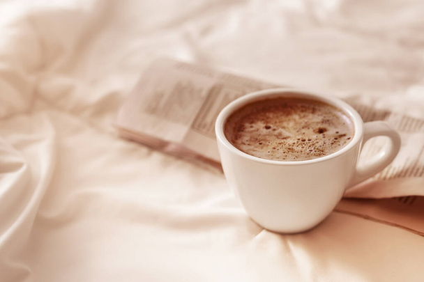 Morning coffee and newspaper on bed. Space for text - Photo, Image
