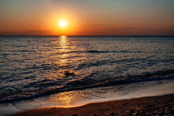 Dramaattinen auringonlasku meren ja vuoren yllä. Valokuvassa Pirgos Sani on Halkidiki Greece
. - Valokuva, kuva