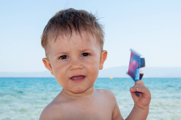 Chlapec s lopatou si hraje na pláži. - Fotografie, Obrázek