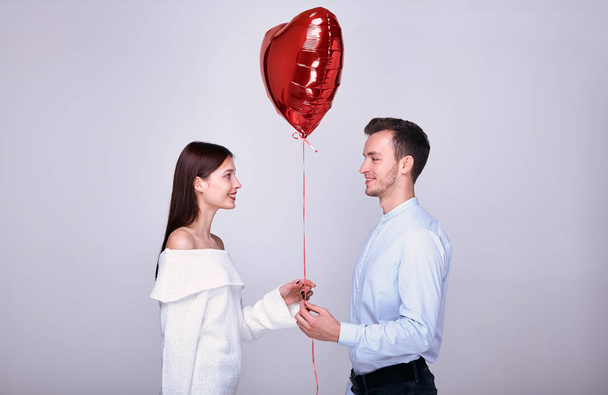 Cute guy gives his beloved balloon on Valentine's Day. - Φωτογραφία, εικόνα