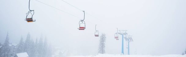 ゴンドラが霧の中に浮かぶ雪の山の景色パノラマ撮影 - 写真・画像