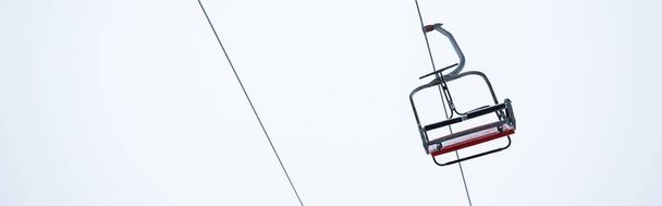 siedzisko gondoli winda na tle czystego białego nieba, zdjęcie panoramiczne - Zdjęcie, obraz