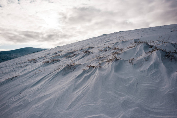 vista panorámica de la colina nevada con cielo nublado en el fondo
 - Foto, Imagen