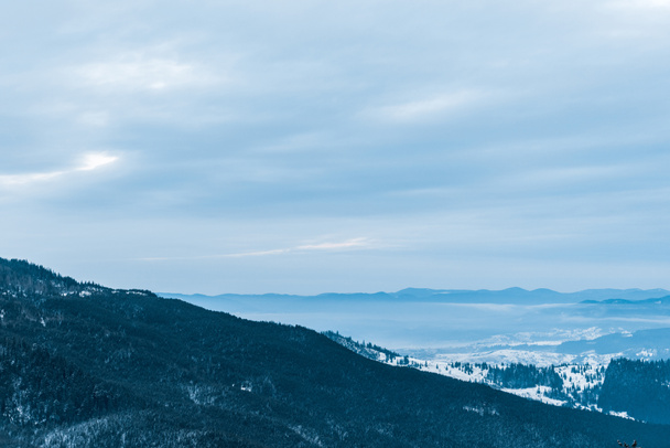 мальовничий вид на засніжені гори і хмарне небо
 - Фото, зображення