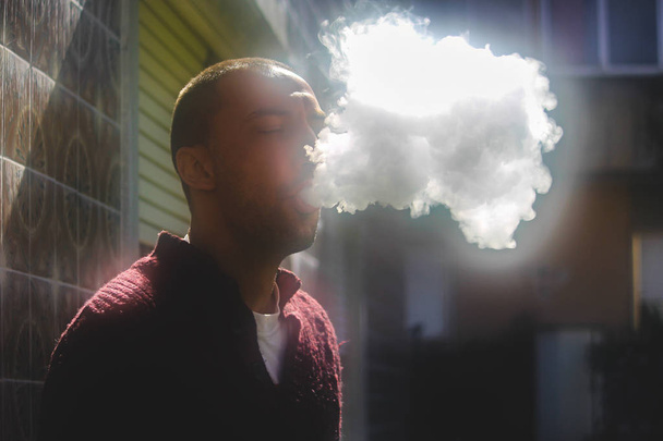 ein Mann, der eine elektronische Zigarette raucht, - Foto, Bild