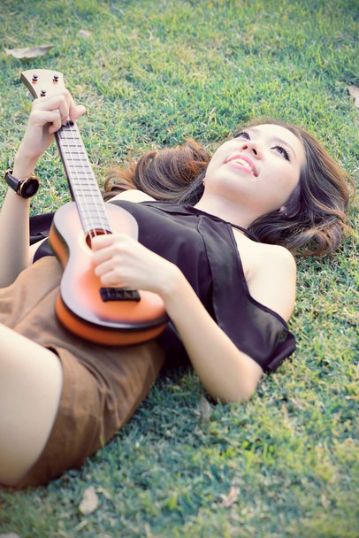 Azië vrouwen spelen ukulele in park vintage Toon - Foto, afbeelding