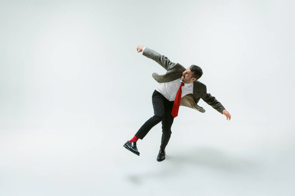 Young caucasian man moving flexible on white studio background - Fotografie, Obrázek