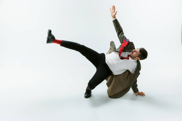 Young caucasian man moving flexible on white studio background - Fotoğraf, Görsel