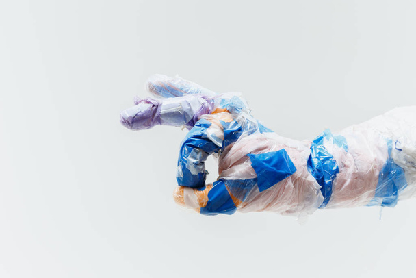 Big plastic hand made of garbage isolated on white studio background - Foto, Imagem