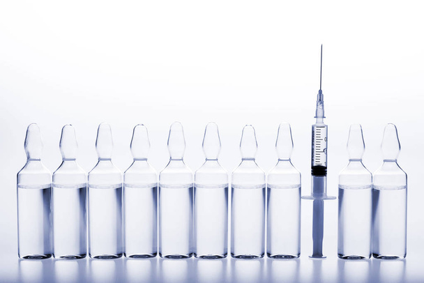 Ampolas de medicina de vidro e seringa no fundo branco - Foto, Imagem
