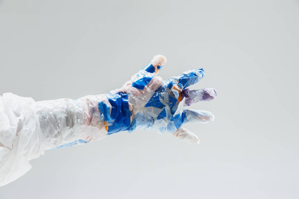 Big plastic hand made of garbage isolated on white studio background - Foto, imagen