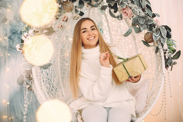 Beautiful girl sitting in a studio with presents - Photo, Image