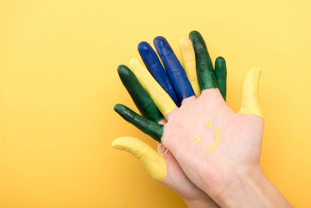 cropped view of man with colorful fingers on yellow background  - Fotografie, Obrázek