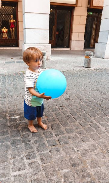 little boy playing with a ball on the street  - Fotografie, Obrázek