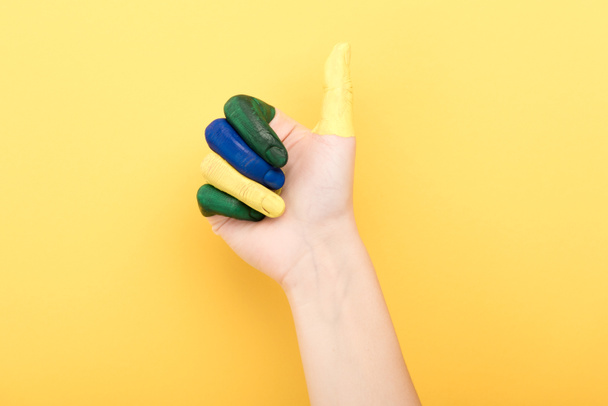 vista ritagliata della donna con le dita colorate che mostrano come su sfondo giallo
  - Foto, immagini