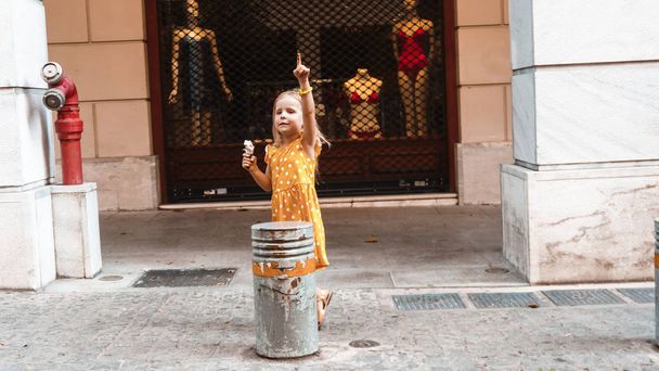 cute little girl eating ice-cream on the street - Fotografie, Obrázek
