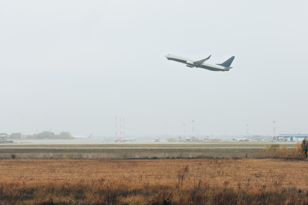 Repülőgép leszálló repülőtér kifutópálya felhős ég a háttérben - Fotó, kép