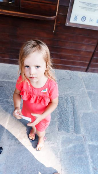 little girl sitting on the floor and looking at the camera - Foto, Bild