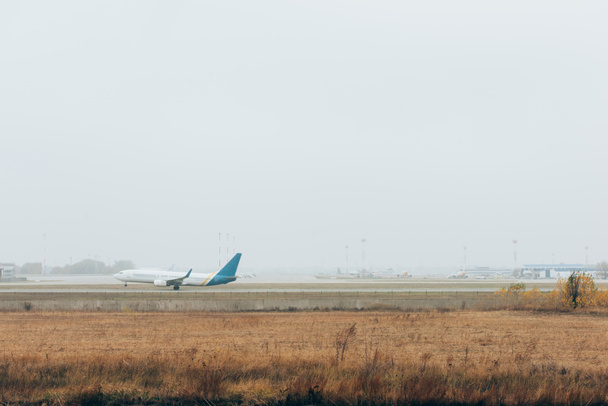 Полет самолета на взлетно-посадочную полосу аэропорта с облачным небом
 - Фото, изображение