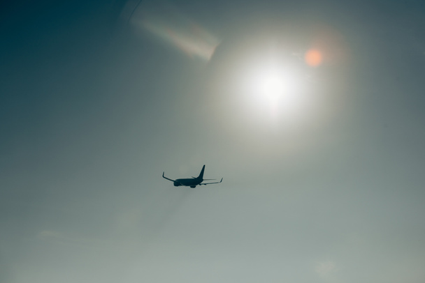 Silhouette d'avion à réaction avec soleil dans un ciel clair
 - Photo, image
