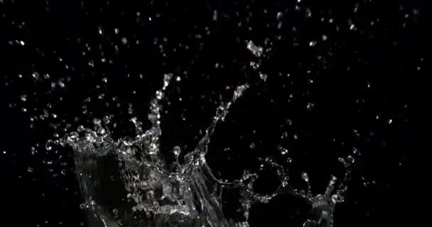 Veden räjähtäminen ja roiskuminen mustaa taustaa vasten, hidastettu liike 4K
 - Materiaali, video