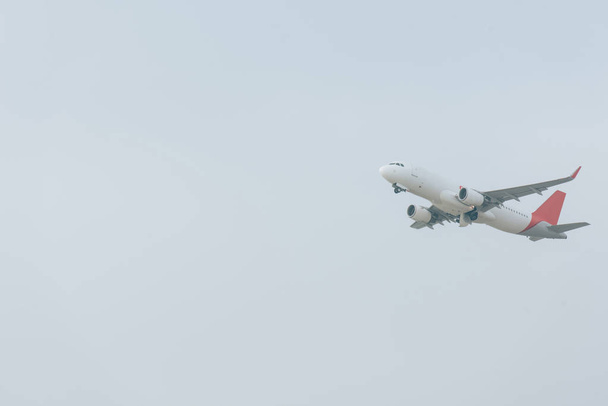 Low angle view of plane landing in cloudy sky - 写真・画像