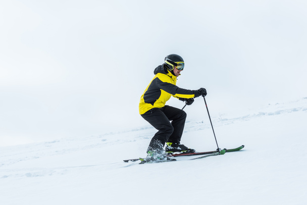 skier holding ski sticks and skiing on slope in wintertime  - Foto, immagini