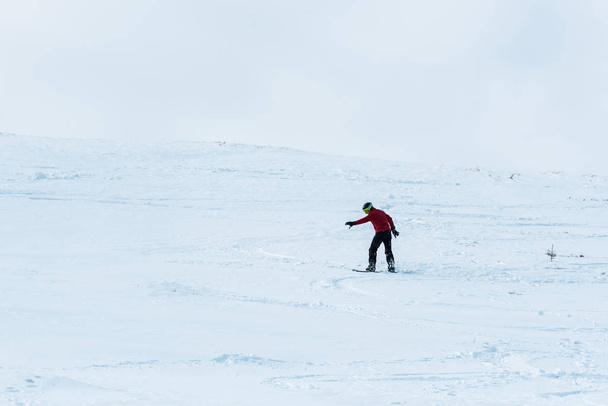snowboarder a cavallo sul pendio con neve bianca all'esterno
  - Foto, immagini