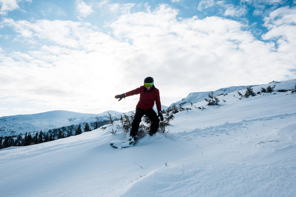 snowboarder en gafas y casco montando en pendiente en invierno
  - Foto, imagen