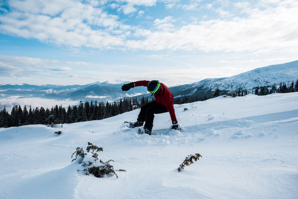 lumilautailija putoaa kun ratsastaa rinteessä vuorilla
  - Valokuva, kuva