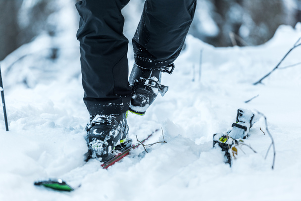 cropped view of skier in walking on snow near skis in winter  - 写真・画像