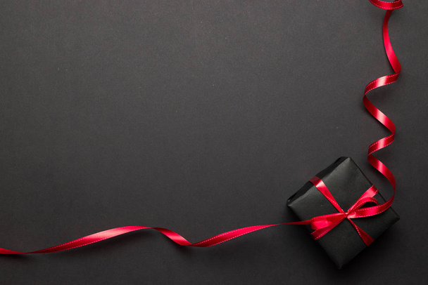 Yeni yıl geçmişi. Siyah arka planda kırmızı kurdeleli Noel hediyeleri. Xmas hediyesi. Kış tatili konsepti. Mutlu Noeller ve mutlu bayramlar tebrik kartı, çerçeve, bayrak - Fotoğraf, Görsel