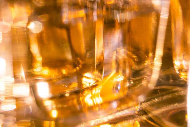 Beautiful bokeh and light reflections in yellow glass perfume bottles - 写真・画像