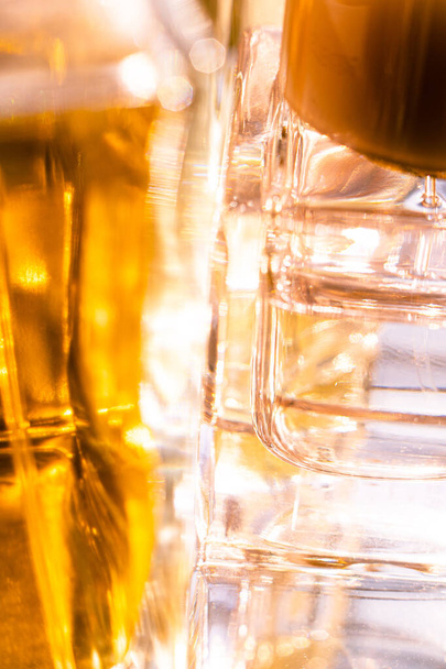 Belles réflexions bokeh et lumière dans des bouteilles de parfum en verre jaune
 - Photo, image