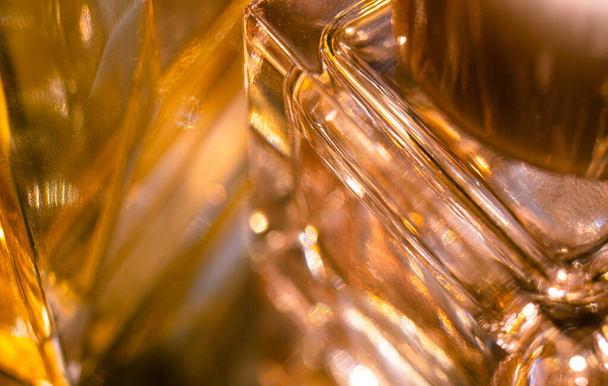 Beautiful bokeh and light reflections in yellow glass perfume bottles - Foto, afbeelding
