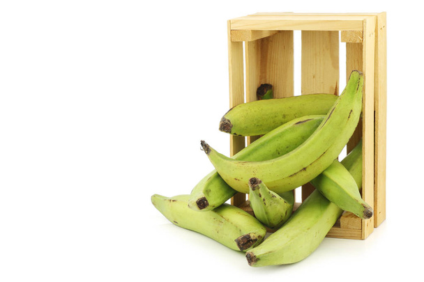 bananas de cozedura não maduras (bananas de bananeira) em uma caixa de madeira em um fundo branco - Foto, Imagem