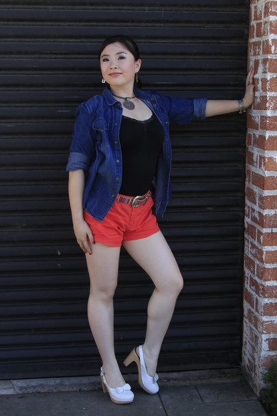 Asian model posing in front of garage door. - Φωτογραφία, εικόνα