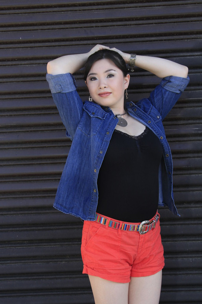 Asian model posing in front of garage door. - Photo, image