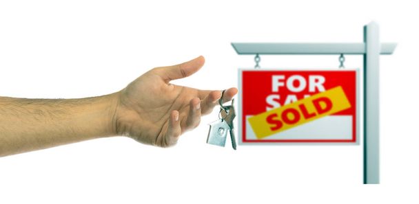 Real estate,  concept. Man holding house keys, blur sold for sale sign, white background. 3d illustration - Photo, Image